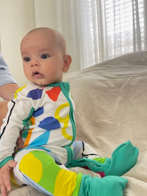 multi coloured long sleeve baby onesie with fold over hand and foot cuffs in unisex design