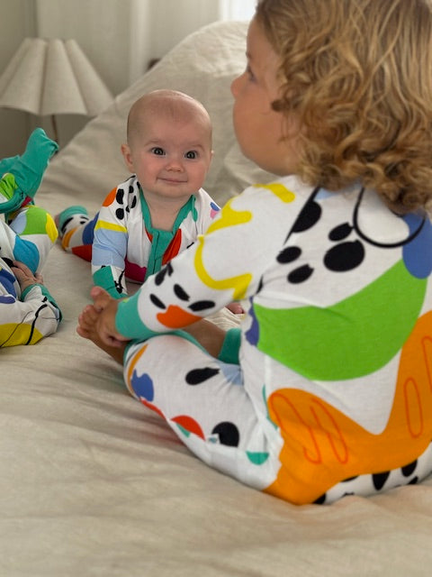 3 x babies in multi coloured long sleeve baby onesie with fold over hand and foot cuffs in unisex design showing different design on each