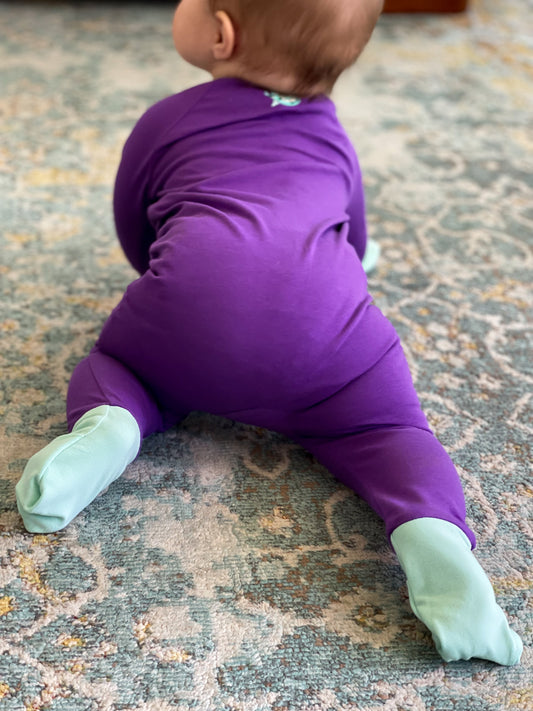 solid purple long sleeve baby onesie with teal trim with fold over hand & foot cuffs and double zip