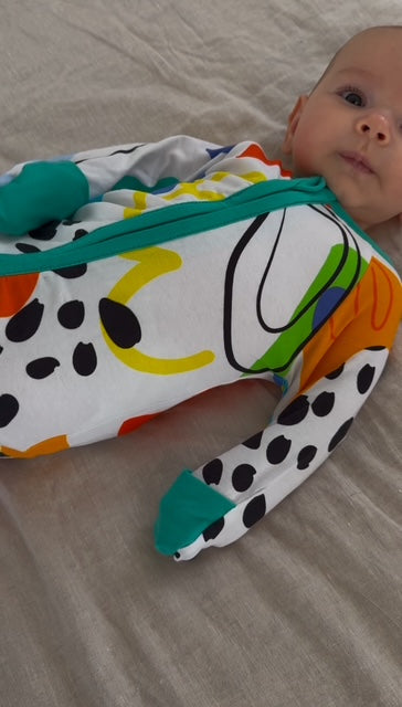 multi coloured long sleeve baby onesie with fold over hand and foot cuffs in unisex design showing attached hand cuffs folded over