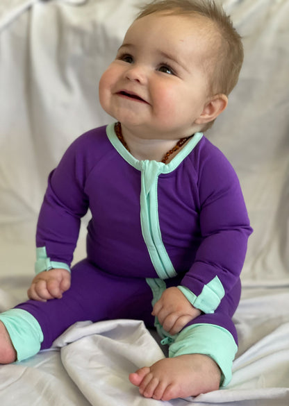 solid purple long sleeve baby onesie with teal trim with fold over hand & foot cuffs and double zip